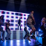 A group of performers on a stage dancing