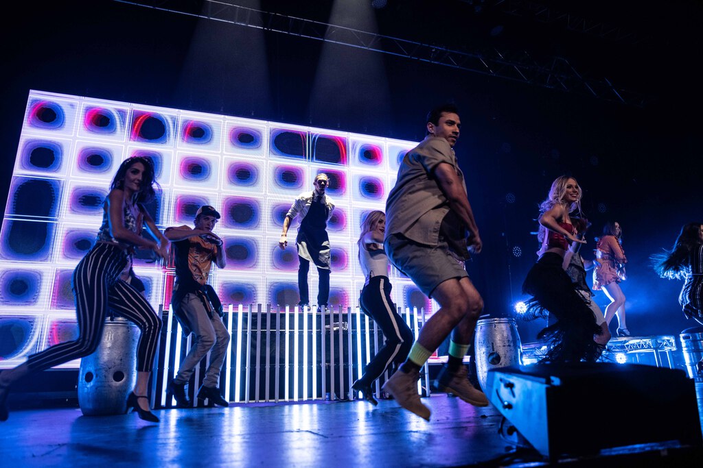 A group of performers on a stage dancing