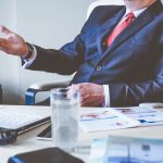 man sitting on a desk in a business suit