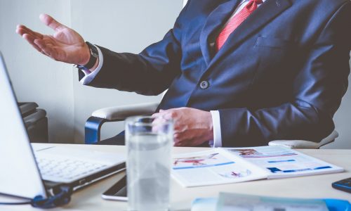 man sitting on a desk in a business suit