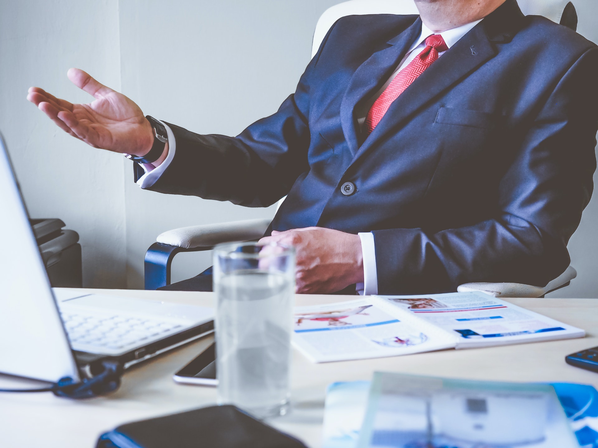 man sitting on a desk in a business suit